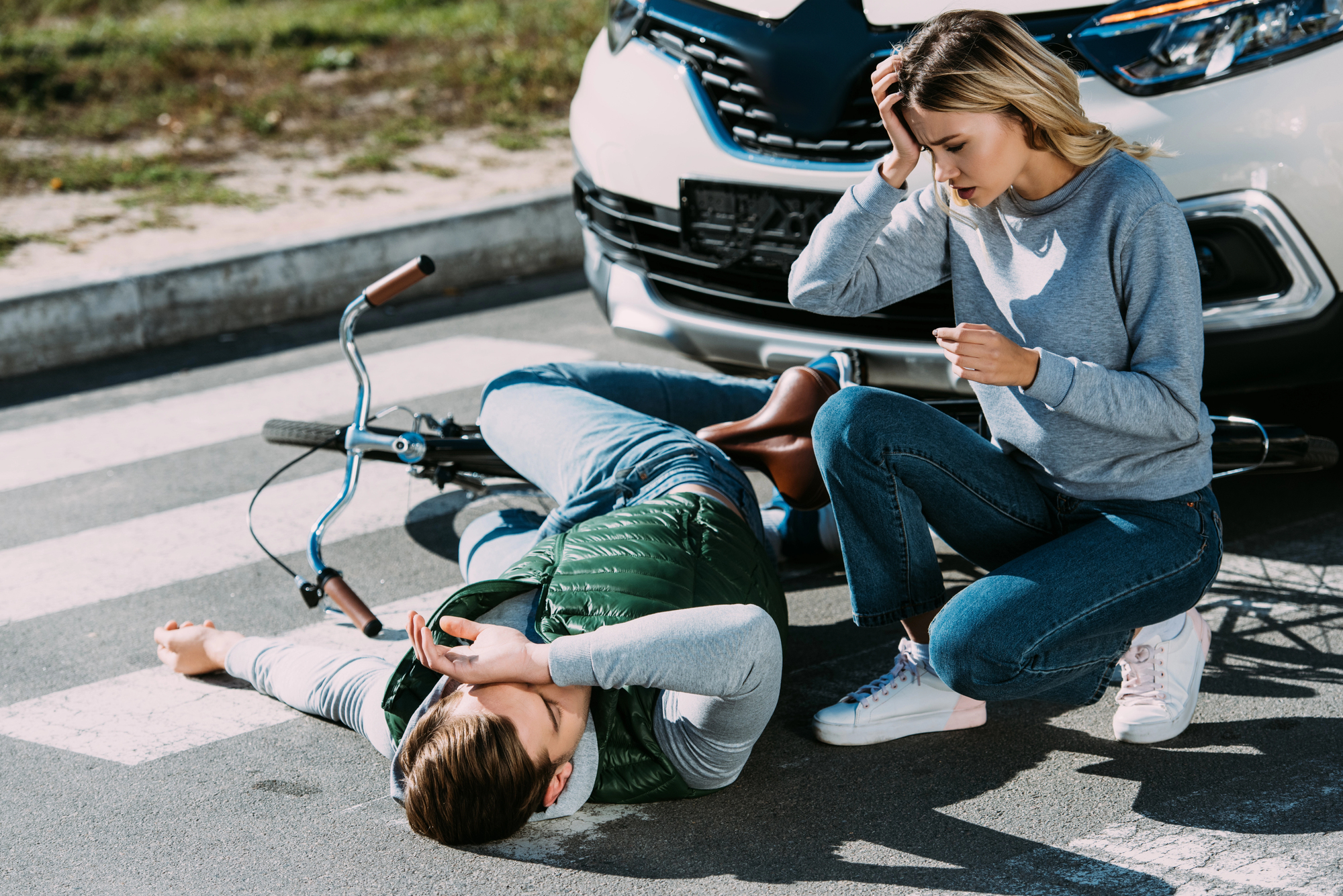 Cyclist receiving assistance after a collision with a vehicle, illustrating bicycle accident claims and injury compensation in Ontario.